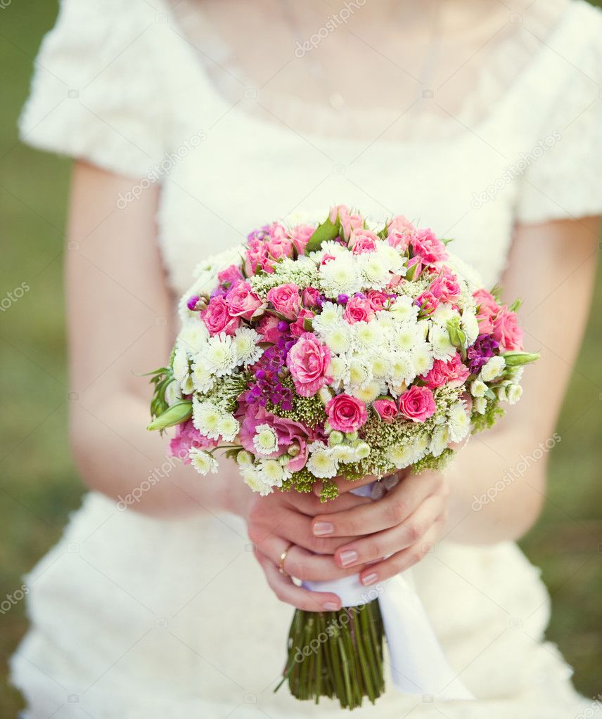 Pink and white wedding bouquet in the hands of the bride