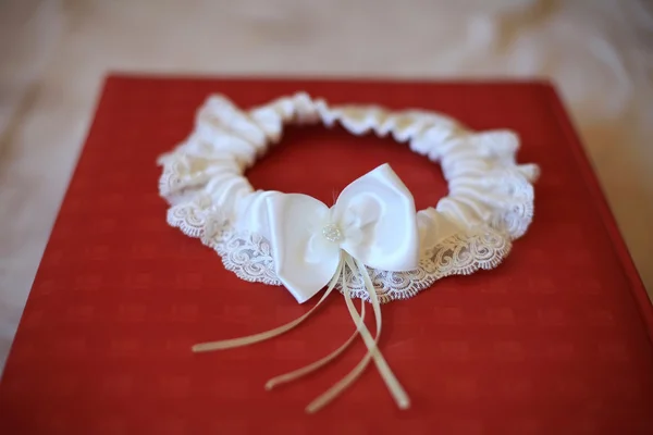 White garter on a red background — Stock Photo, Image