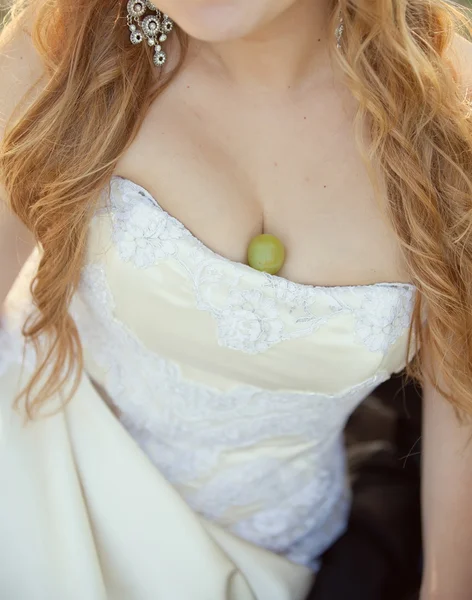 Bride in a white dress with green grapes — Stock Photo, Image