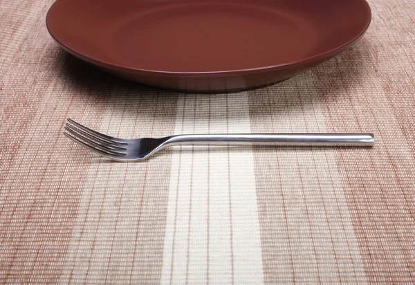 Пустая тарелка с вилкой — стоковое фото