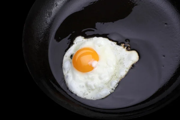 Uova fritte su pentola nera — Foto Stock