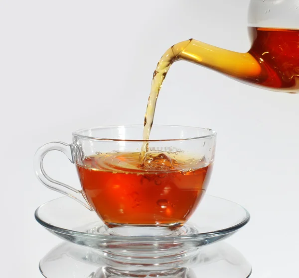 Verser le thé dans une tasse de thé — Photo