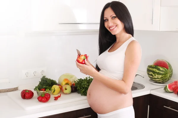 Pregnant woman in kitchen Stock Image