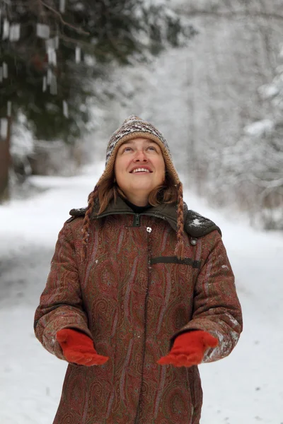 Mooi meisje kijkend naar de dalende sneeuw — Stockfoto
