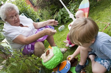 Gran and gran children playing outside in the garden clipart