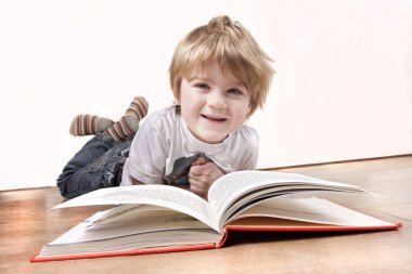 Young 4 year old boy reading a book clipart