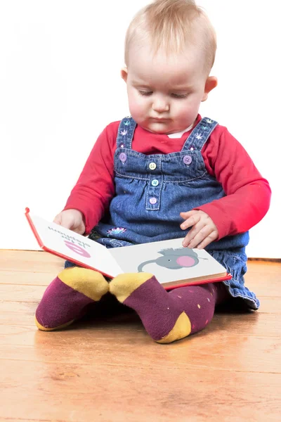 Маленькая девочка счастливо читает книгу — стоковое фото