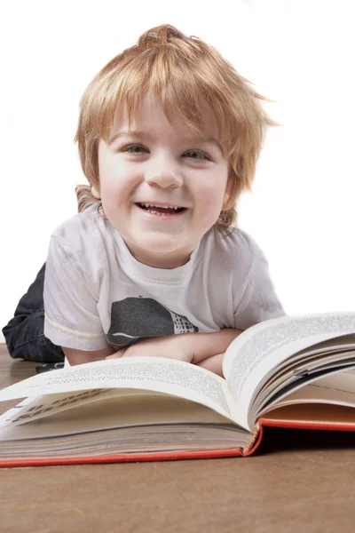 Glücklicher kleiner Junge liest und lächelt — Stockfoto