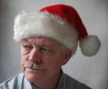 Annoyed senior with a Santa hat clipart