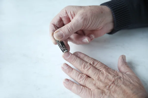 Uomo più anziano tagliare le unghie — Foto Stock