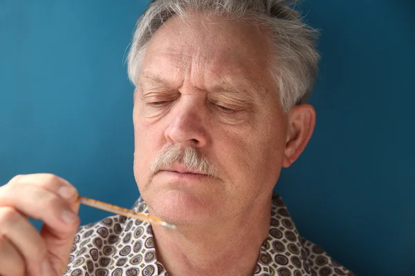 Chory starszy sprawdza jego gorączka — Zdjęcie stockowe