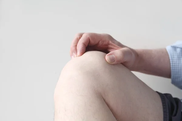 Homem agarra seu joelho dolorido — Fotografia de Stock