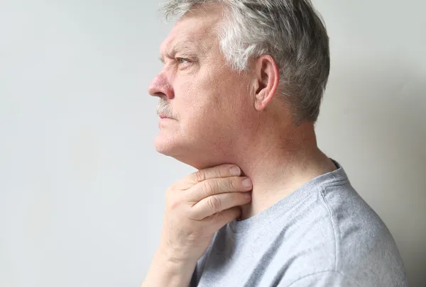 Mann mit Halsschmerzen Stockbild