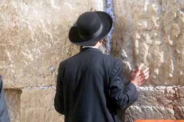 Jewish men pray at the western wall clipart