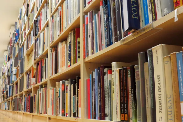 Bokhylla i bibliotek med många böcker — Stockfoto