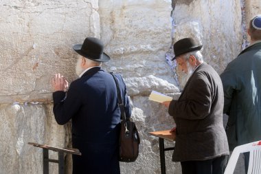 Jewish men pray at the western wall clipart