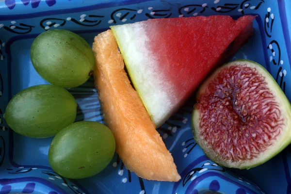 Uvas, higos, sandía y melón en un bol azul —  Fotos de Stock