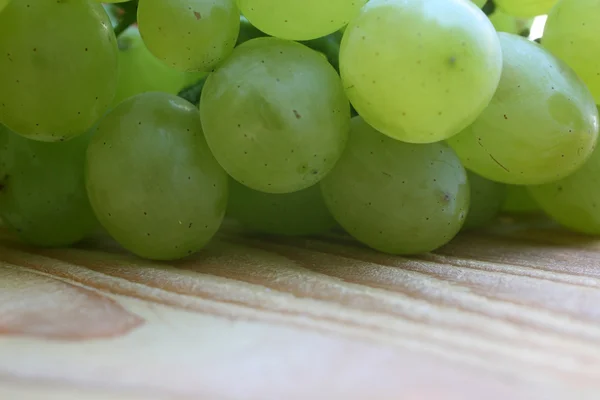 Виноград на деревянном столе — стоковое фото