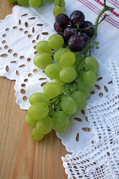 Виноградне скупчення на білій скатертині — стокове фото
