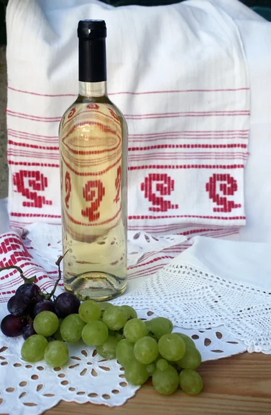 Butelka białego wina i winogron — Zdjęcie stockowe