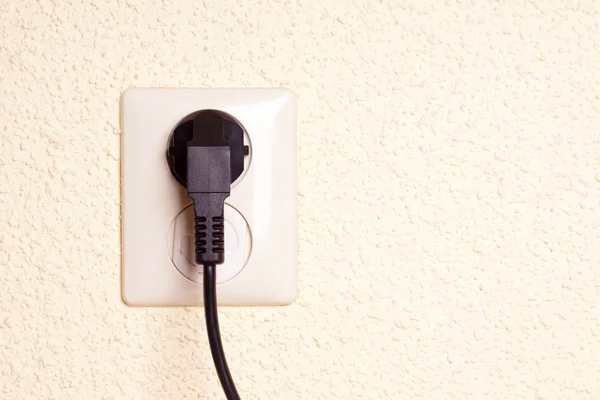 Tomada com plug contra um fundo texturizado — Fotografia de Stock