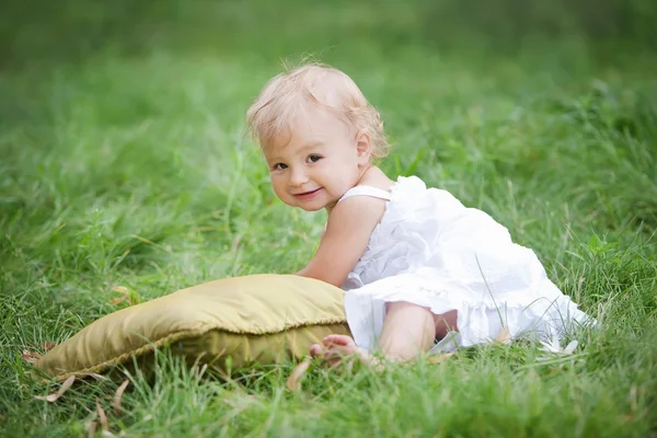 坐在绿草地上的婴儿 — 图库照片
