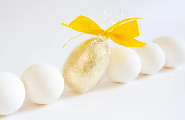 White eggs and golden easter egg — Stock Photo, Image