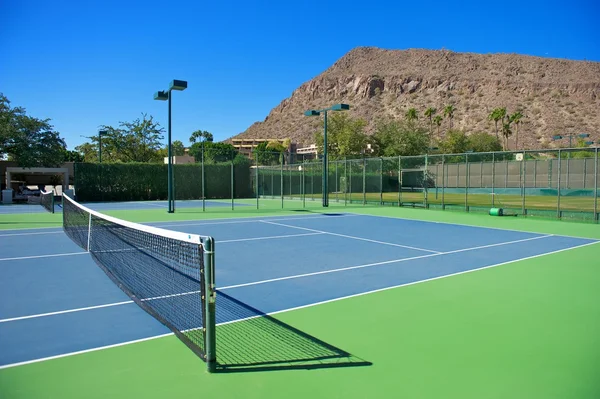度假村的蓝网球场 免版税图库照片