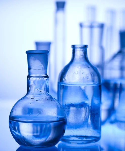 Equipamento de laboratório de vidro com fundo azul — Fotografia de Stock