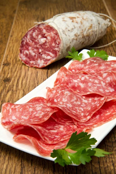 Salami sliced on wood background — Stock Photo, Image