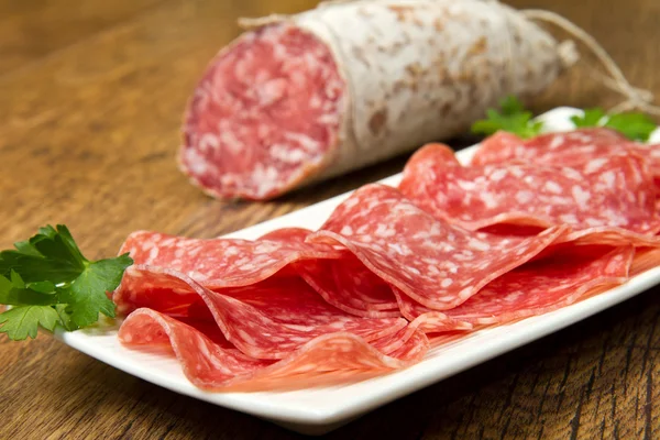 Salami sliced on wood background — Stock Photo, Image