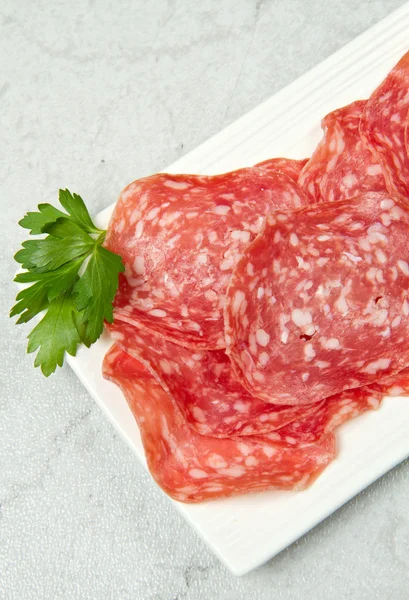 Salami sliced on marble table — Stock Photo, Image