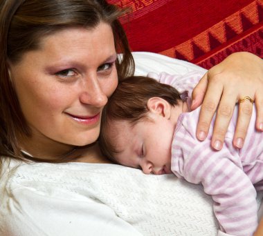 Annesi kucaklayan bebek uykuda