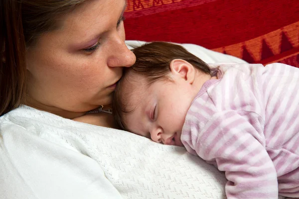 Matka całuje dziecko śpi — Zdjęcie stockowe