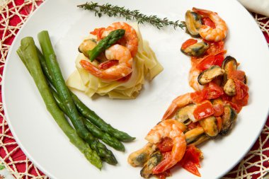 Pasta with shrimp, mussels and fresh asparagus clipart