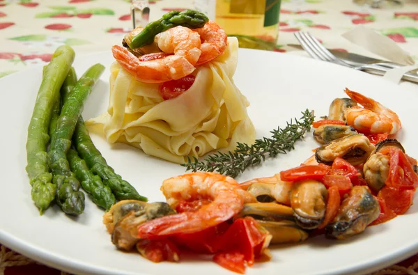 Pasta with shrimp, mussels and fresh asparagus — Stock Photo, Image
