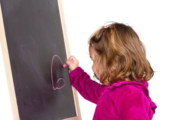小さな女の子が黒板に書く — ストック写真
