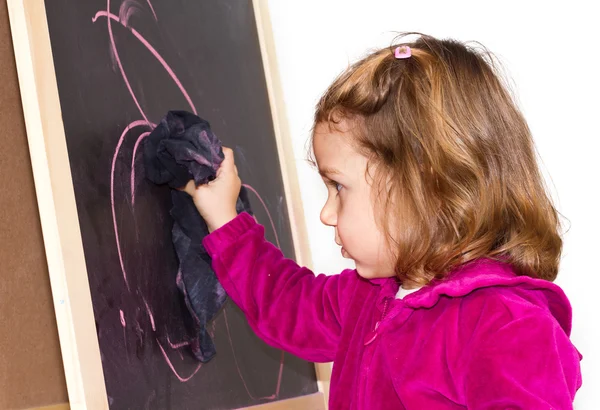Маленькая девочка пишет на доске — стоковое фото