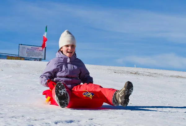 Uma menina deslizando na neve — Fotografia de Stock