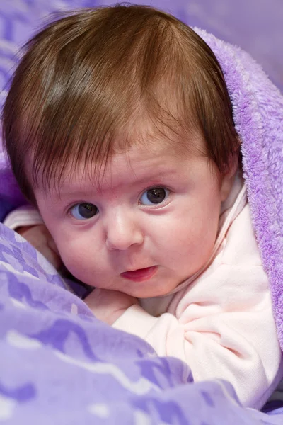 Младенец, выглядывающий из-под одеяла — стоковое фото