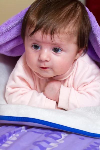 Baby kijken uit van onder deken — Stockfoto
