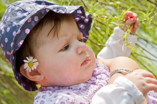 Bebê brincando com lâmina de grama — Fotografia de Stock