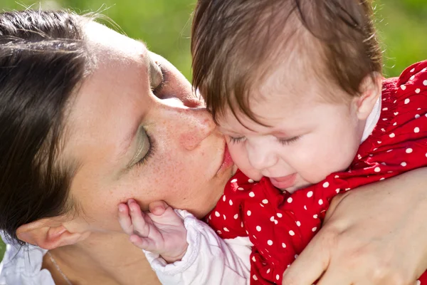 妈妈亲吻宝宝在公园 — 图库照片