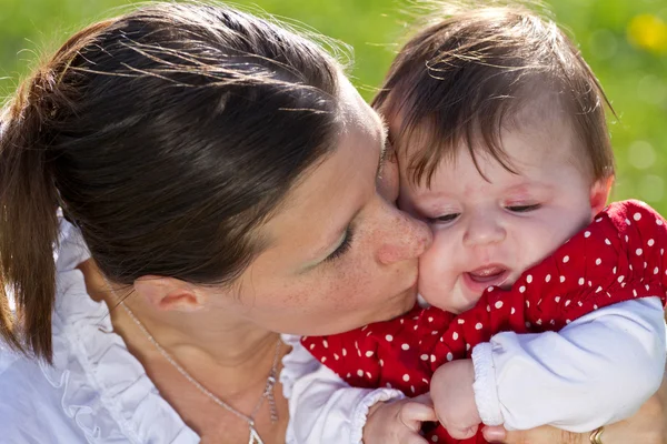 Мать целует ребенка — стоковое фото