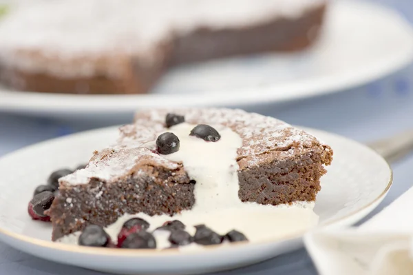 Bolo de chocolate com mirtilos e molho de baunilha quente — Fotografia de Stock