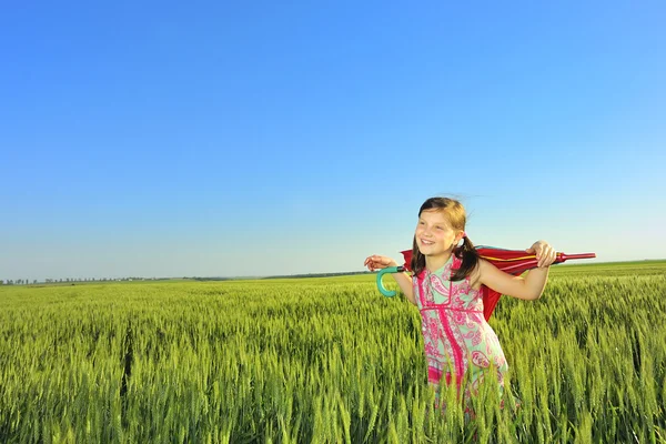 La bambina su un campo con un ombrello — Foto Stock