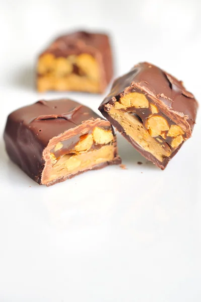 Chocolate covered bar with caramel and hazelnut — Stock Photo, Image