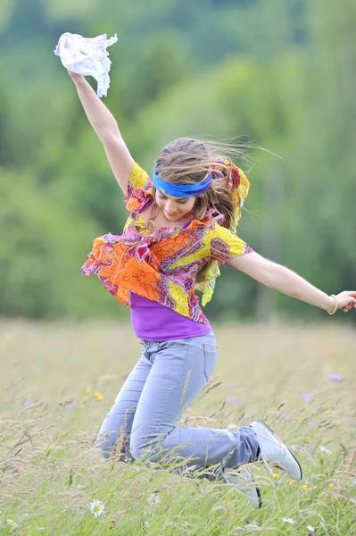 Springen meisje tegen zomer weide — Stockfoto