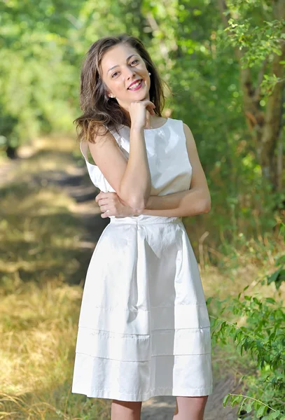Beauty girl in a fashioned dress in a forest — Stock Photo, Image