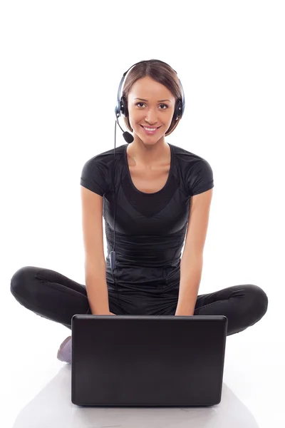 Young woman in neadphones with laptop on a white — Stock Photo, Image